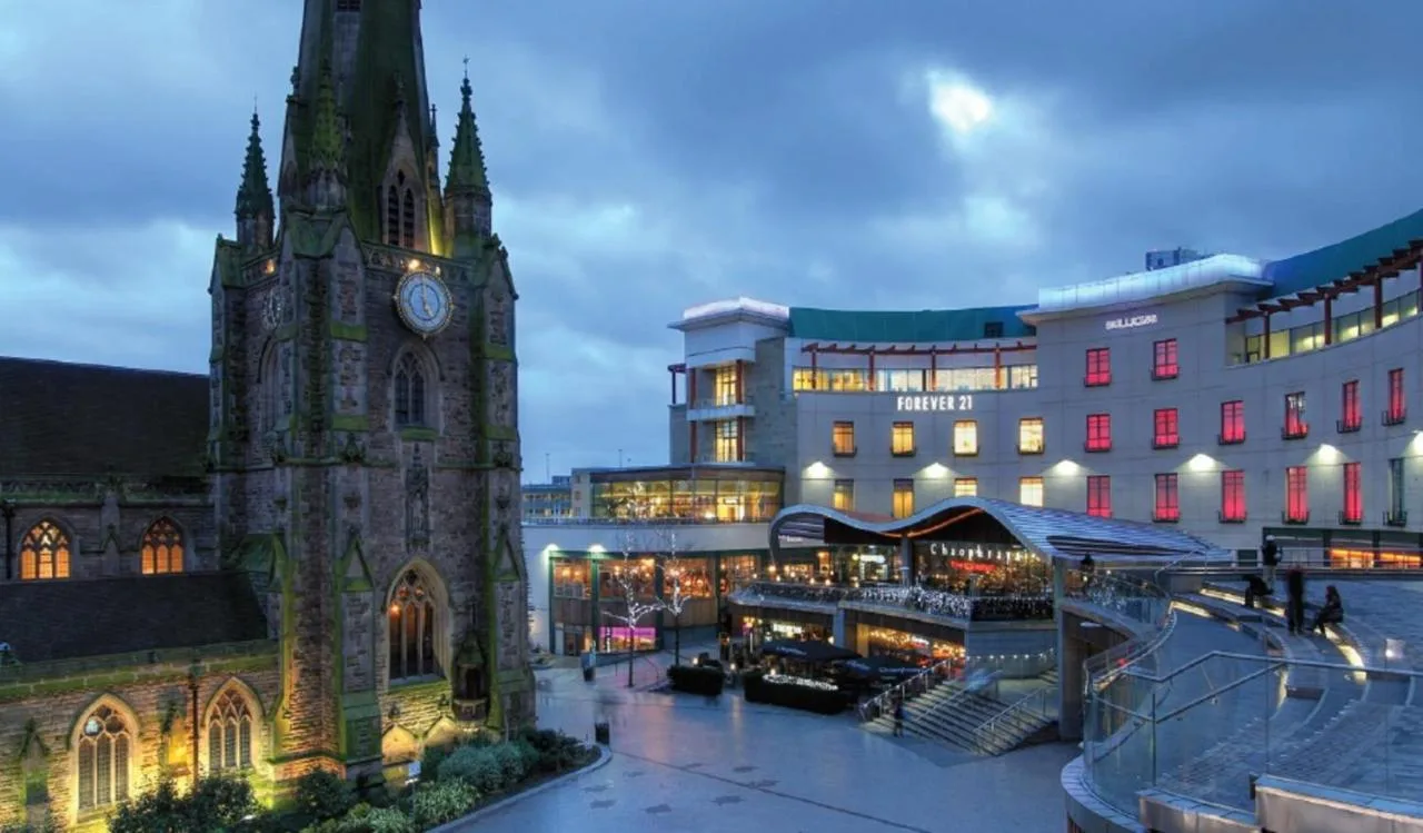 a building with a clock tower next to a building at Crowne Plaza Birmingham City by IHG in Birmingham