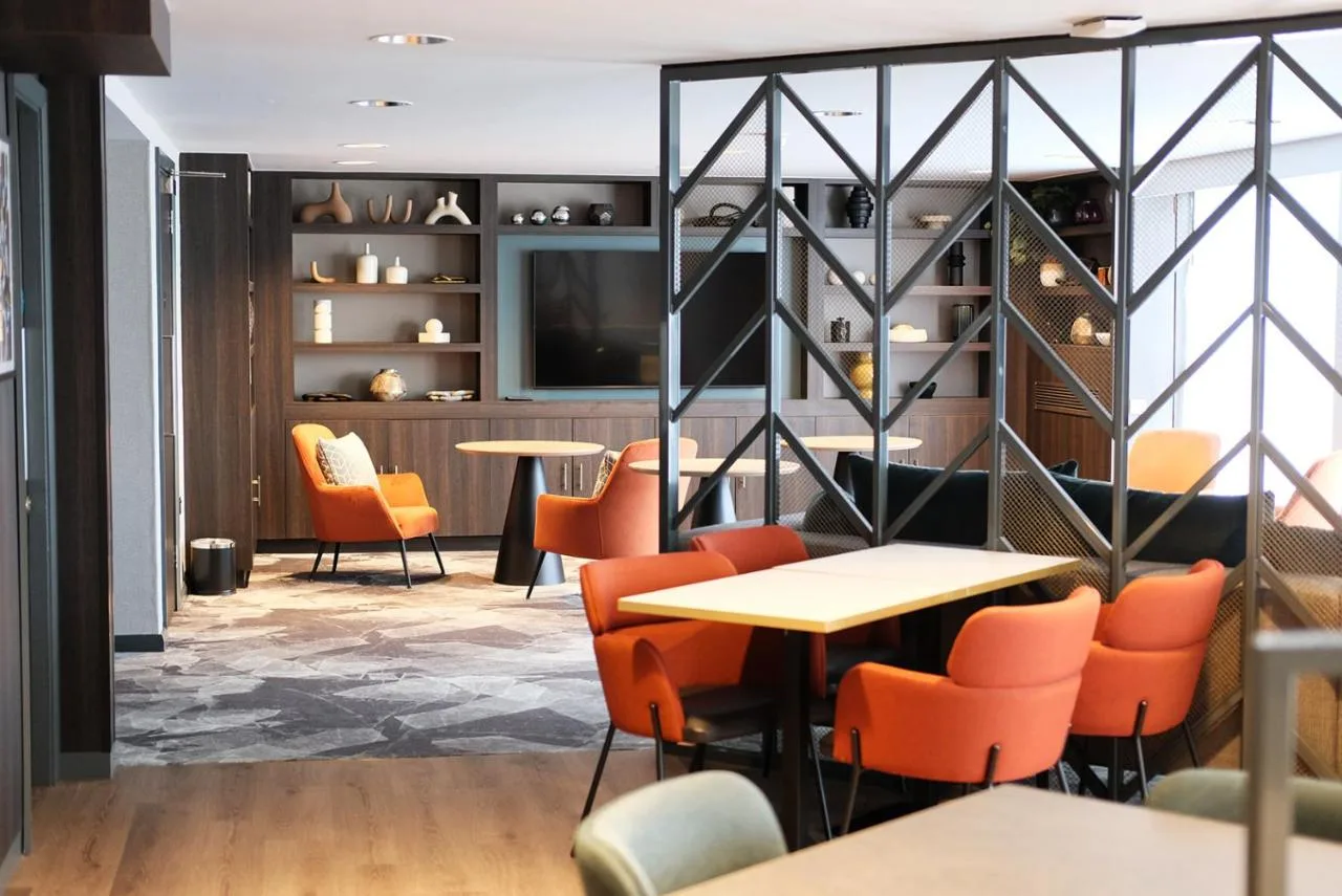 a restaurant with orange chairs and tables at Crowne Plaza Birmingham City by IHG in Birmingham
